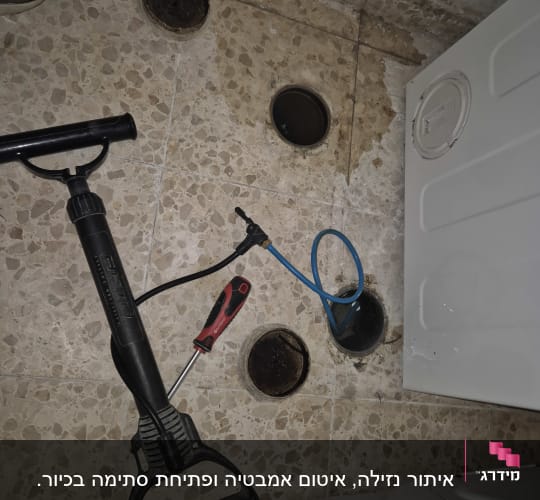 כלי עבודה וצינור כחול על רצפת אריחים